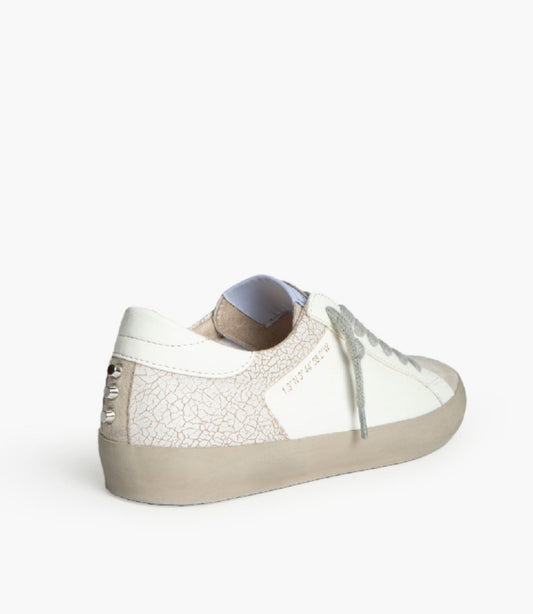 Sapatilhas brancas, biqueira taupe e tachas atrás