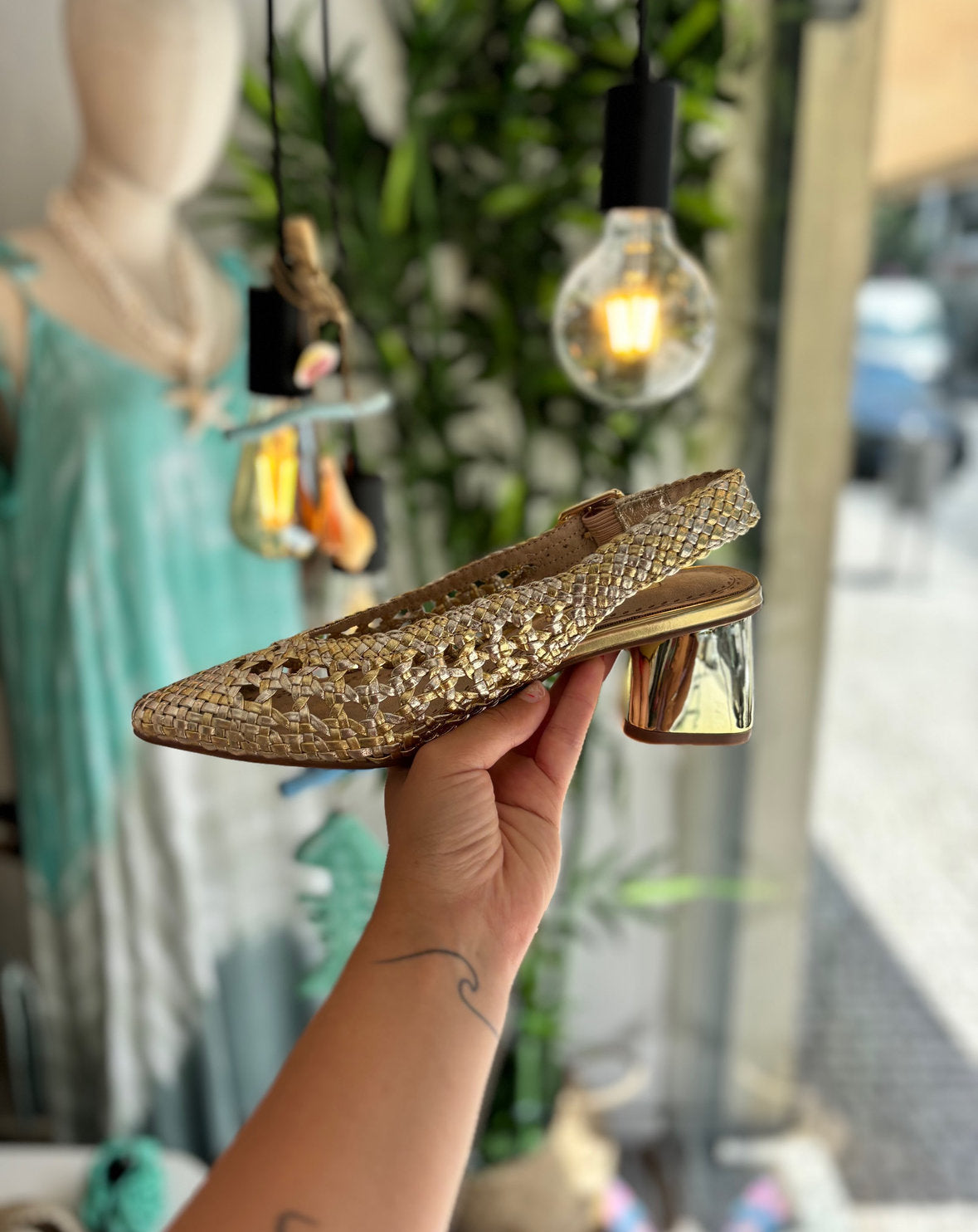 Mule trenzado dorado con tacón y hebilla