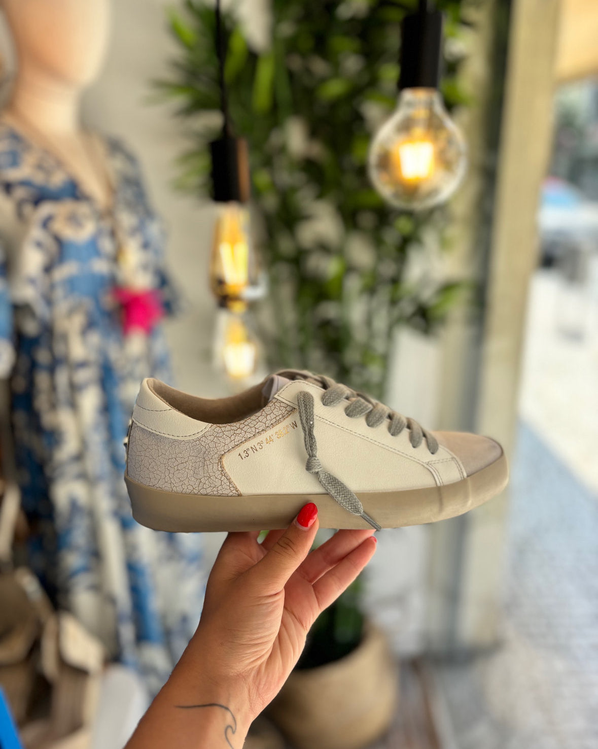 Sapatilhas brancas, biqueira taupe e tachas atrás