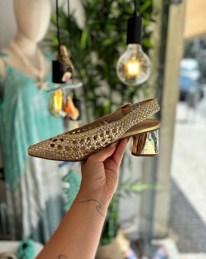 Mule trenzado dorado con tacón y hebilla