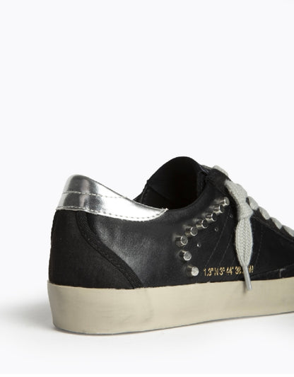 Sapatilhas pretas com tachas laterais